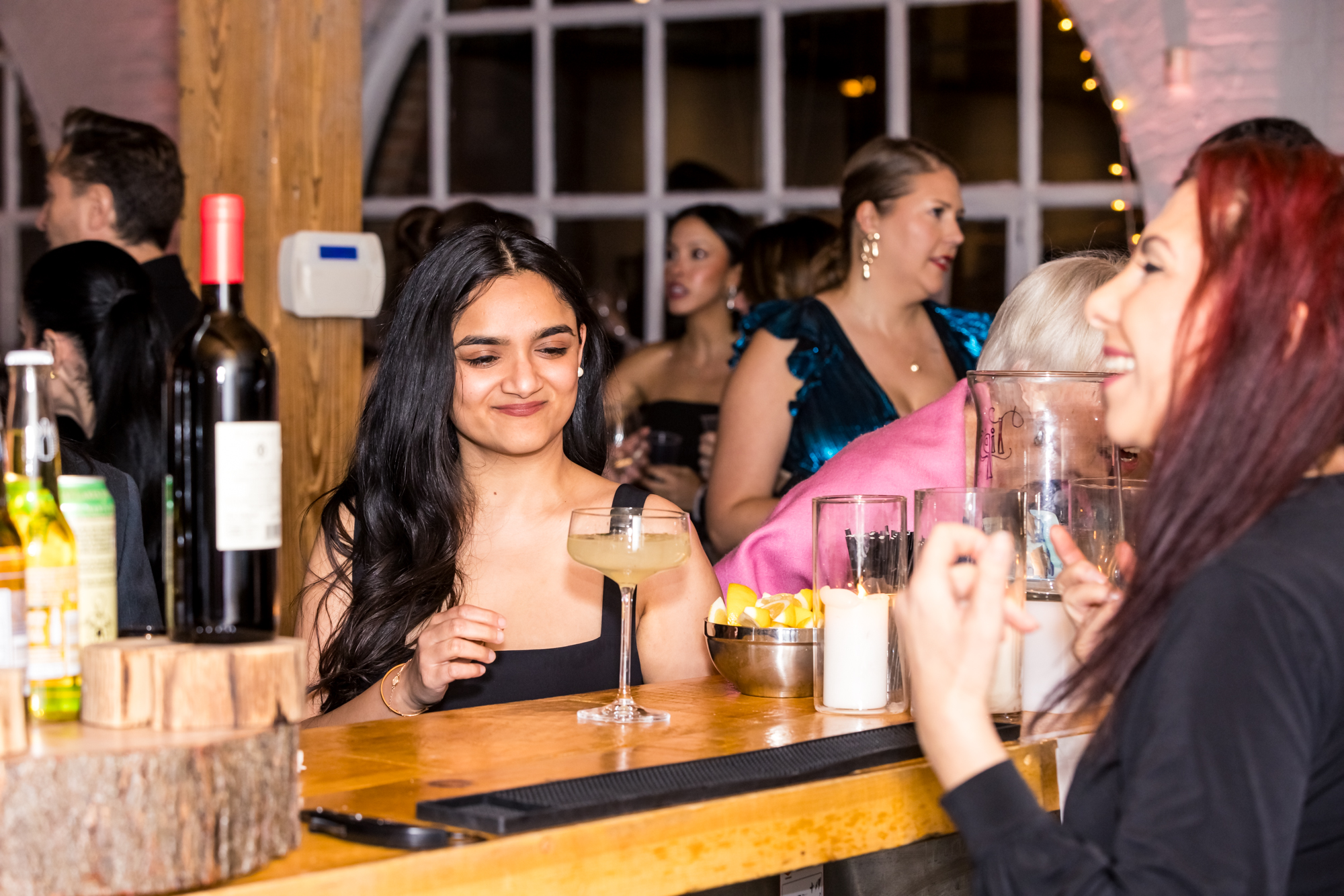 Guests enjoying cocktails at a custom wooden bar