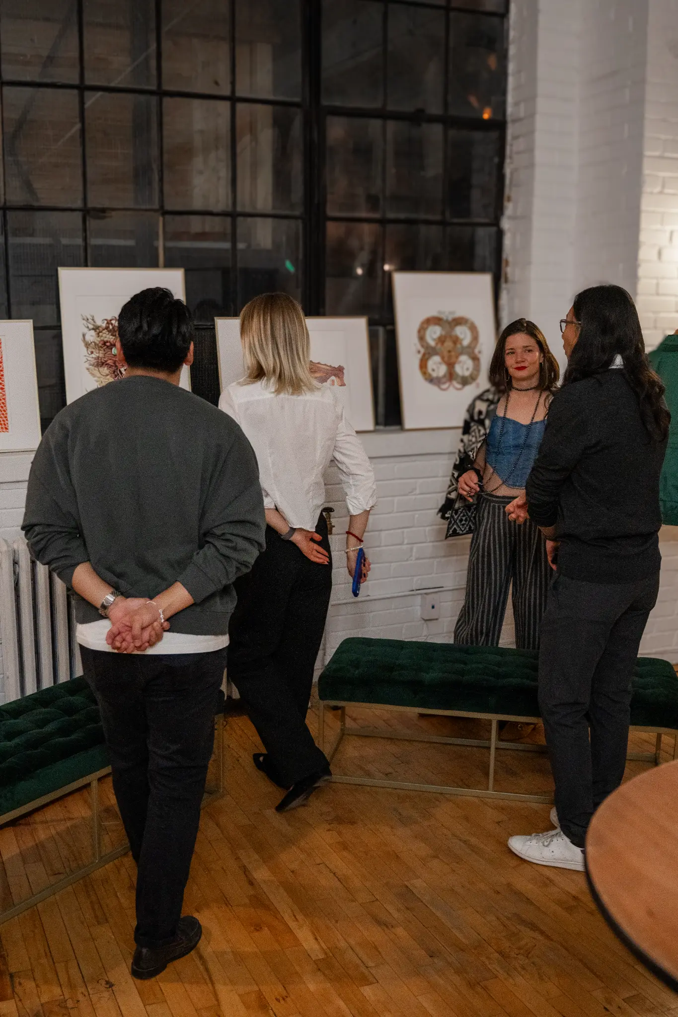 Guests chatting among artwork in a welcoming gallery setting