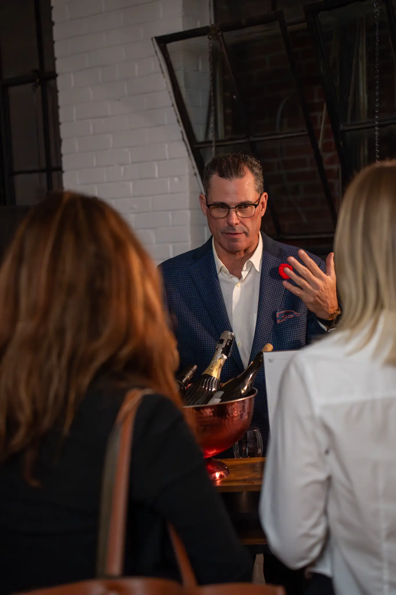 Guests in conversation beside a drinks station at an intimate event